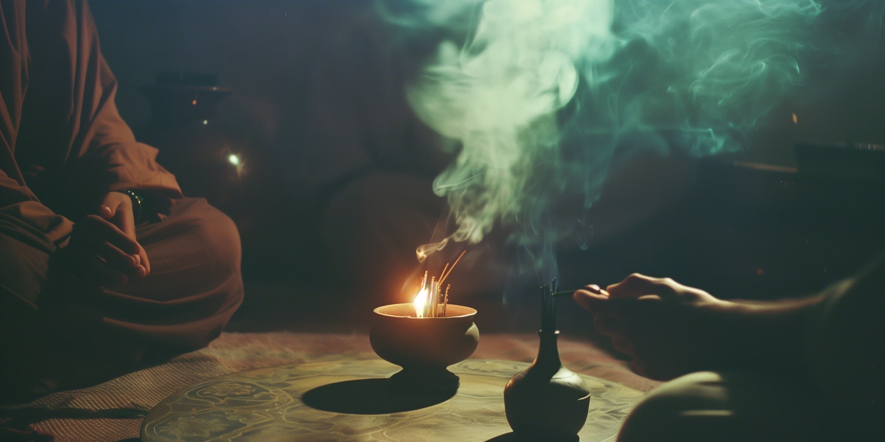 An oil lamp and incense between a teacher and student seated together
